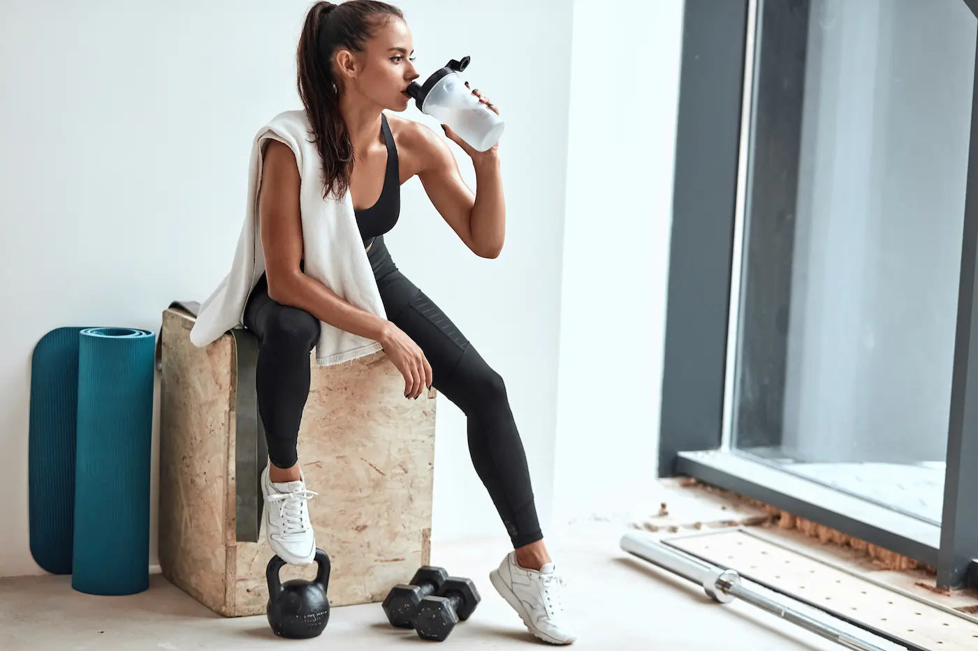 Woman preparing for a workout with clean preworkout supplement